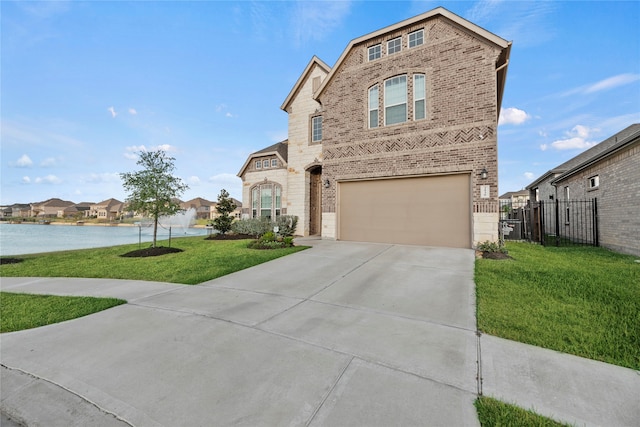 view of front of house featuring a garage, a water view, and a front yard