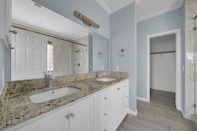 bathroom with vanity, a shower with shower door, and ornamental molding