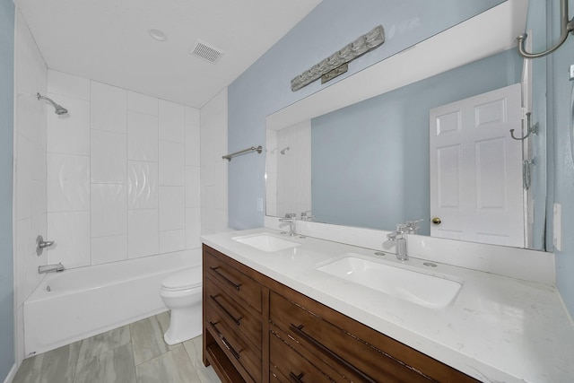 full bathroom featuring vanity, toilet, and tiled shower / bath combo