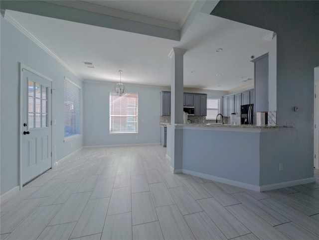 kitchen with gray cabinetry, crown molding, kitchen peninsula, and an inviting chandelier