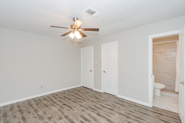 unfurnished bedroom with light wood-type flooring, ensuite bath, and ceiling fan