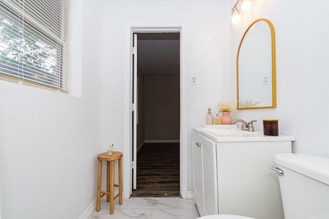 2002 Nottingham St, Pasadena, TX 77502 - bathroom featuring toilet, baseboards, marble finish floor, and vanity