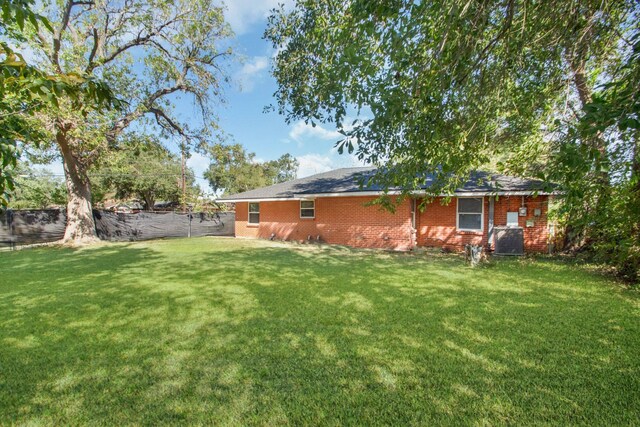 2002 Nottingham St, Pasadena, TX 77502 - back of house with cooling unit, a yard, brick siding, and a fenced backyard