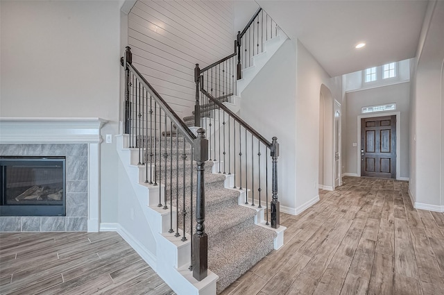 entrance foyer featuring a high ceiling, hardwood / wood-style flooring, and a tiled fireplace