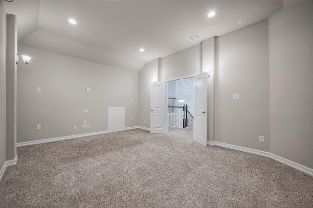 spare room with carpet flooring and lofted ceiling