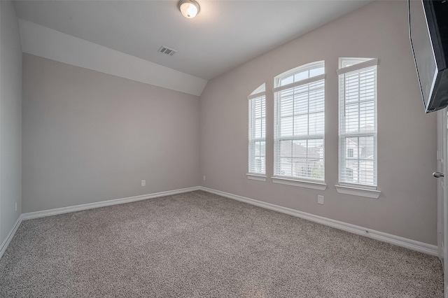 unfurnished room featuring carpet and lofted ceiling