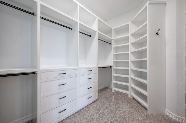 walk in closet featuring light colored carpet