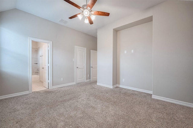 unfurnished bedroom featuring ensuite bath, ceiling fan, light carpet, and vaulted ceiling