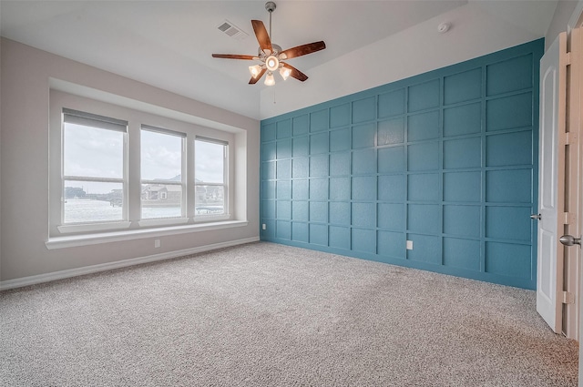 spare room with ceiling fan and carpet