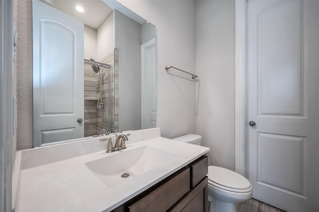 bathroom featuring vanity, toilet, and walk in shower