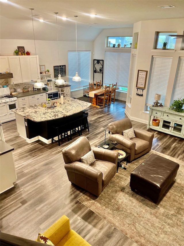 living room with high vaulted ceiling and light wood-type flooring