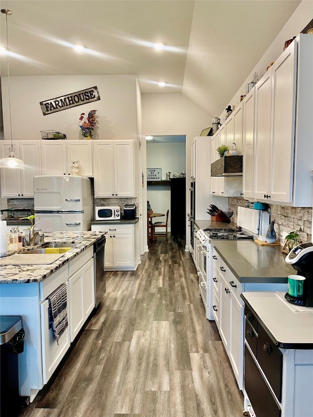 kitchen featuring decorative backsplash, white cabinets, pendant lighting, and appliances with stainless steel finishes