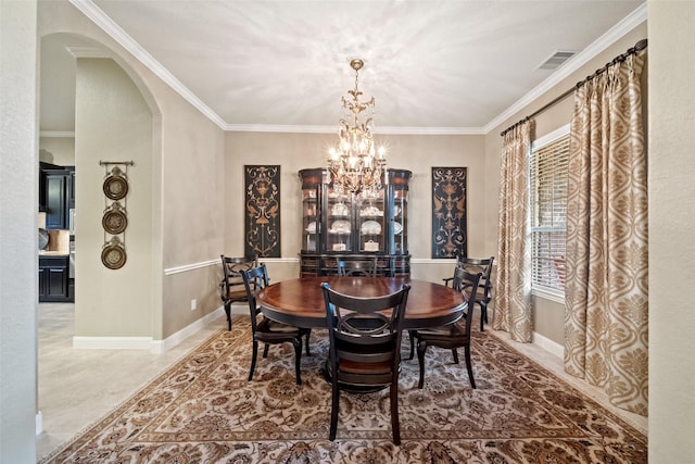 dining area featuring baseboards, visible vents, arched walkways, and a notable chandelier