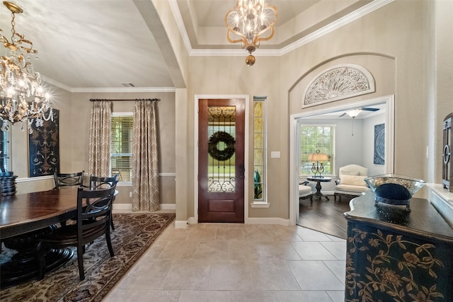 entryway featuring a wealth of natural light, light hardwood / wood-style flooring, crown molding, and a notable chandelier