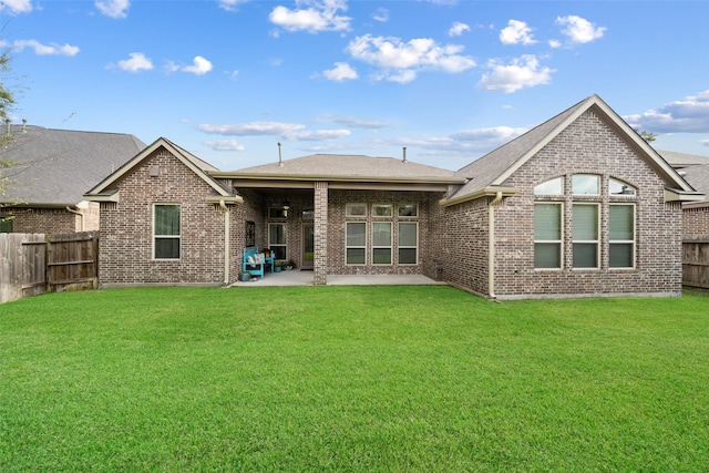 back of house featuring a lawn, a fenced backyard, ceiling fan, a patio area, and brick siding