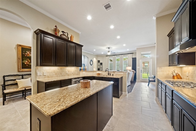 kitchen featuring kitchen peninsula, stainless steel appliances, a kitchen island, and backsplash