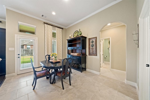 dining space featuring arched walkways, light tile patterned flooring, visible vents, baseboards, and crown molding