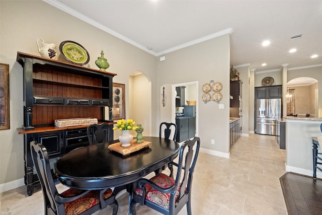 dining room featuring recessed lighting, baseboards, arched walkways, and ornamental molding