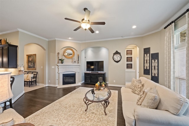 living room with dark wood-style floors, arched walkways, crown molding, and baseboards