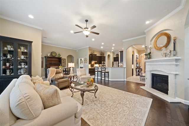 living room featuring dark wood-type flooring, ceiling fan, and crown molding