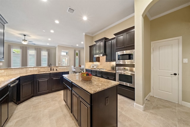 kitchen with a center island, visible vents, backsplash, appliances with stainless steel finishes, and a sink