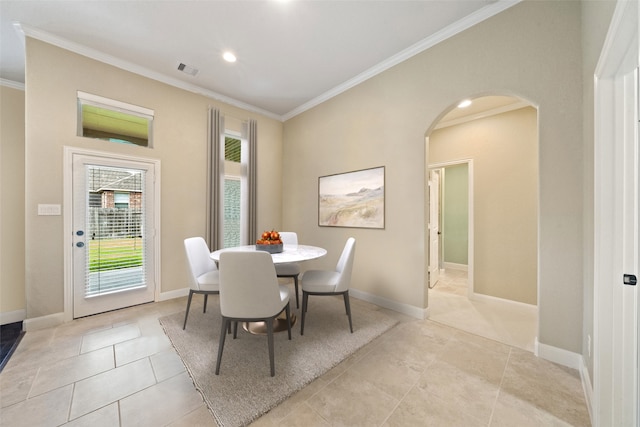 dining area featuring arched walkways, light tile patterned floors, visible vents, baseboards, and ornamental molding