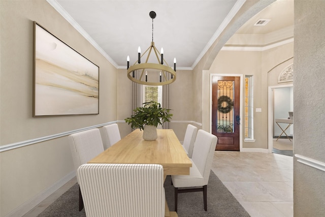 dining room featuring ornamental molding, visible vents, a notable chandelier, and baseboards