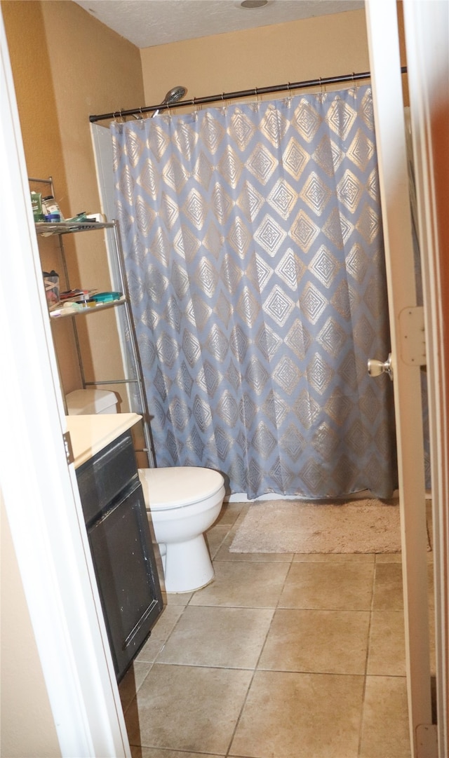 bathroom featuring tile patterned flooring, vanity, and toilet