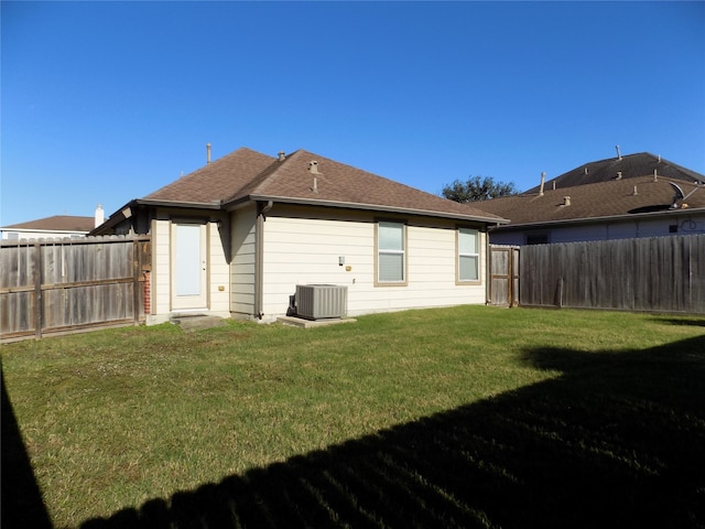 back of property with a yard and central AC unit