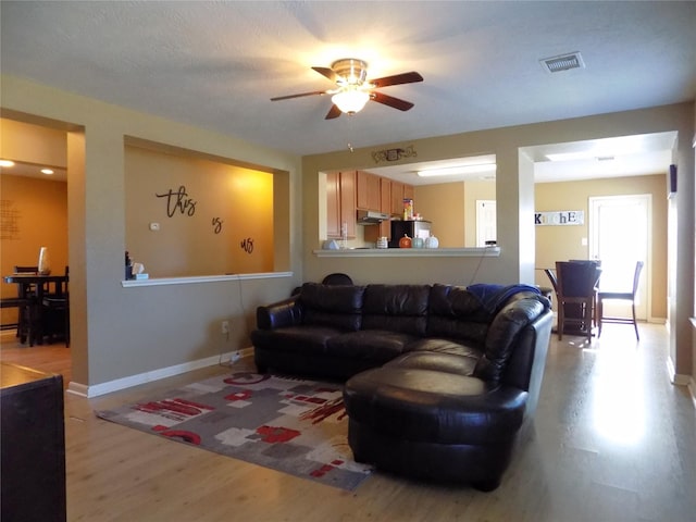 living room featuring ceiling fan and light hardwood / wood-style floors