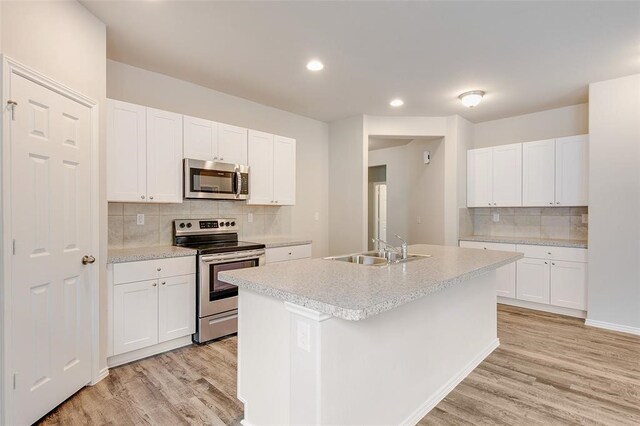 kitchen featuring white cabinetry, sink, light wood-type flooring, and appliances with stainless steel finishes