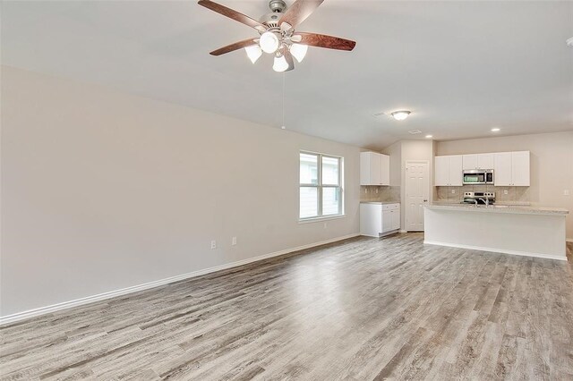 unfurnished living room with ceiling fan and light hardwood / wood-style flooring