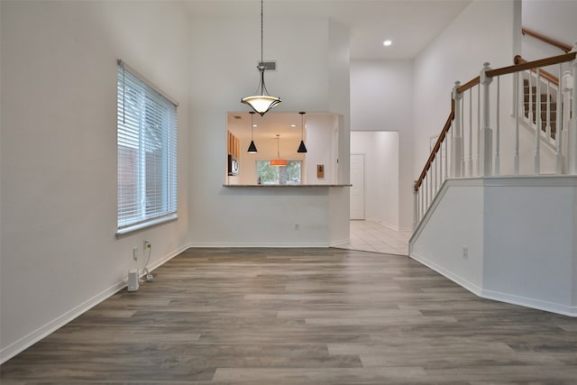 unfurnished living room featuring hardwood / wood-style flooring and a high ceiling