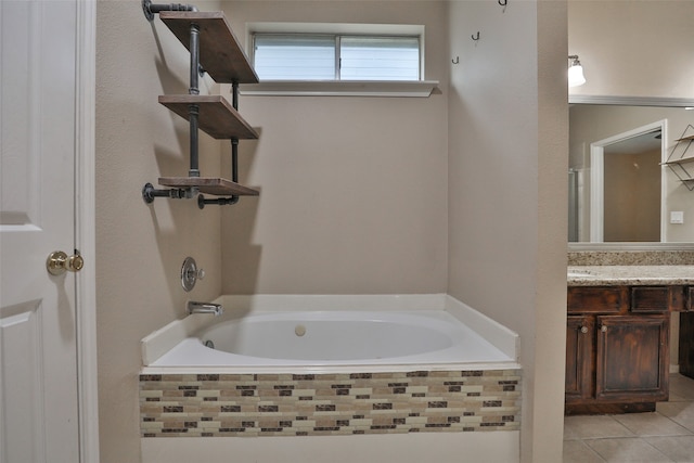 bathroom with vanity, tiled bath, and tile patterned flooring