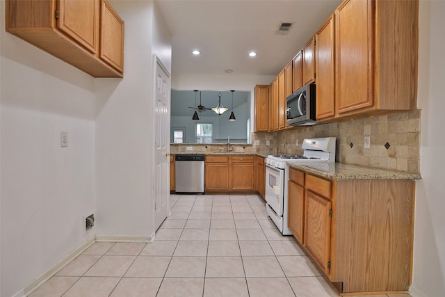 kitchen featuring light tile patterned flooring, stainless steel appliances, decorative light fixtures, sink, and ceiling fan