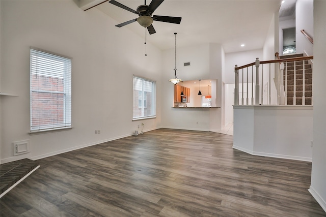 unfurnished living room featuring dark wood-type flooring, high vaulted ceiling, and ceiling fan