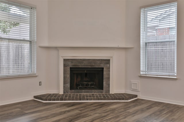 interior details with wood-type flooring and a brick fireplace