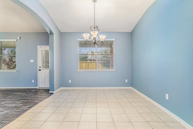 unfurnished room featuring light tile patterned floors and a notable chandelier