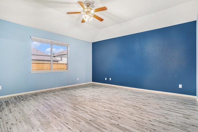 empty room featuring ceiling fan, light hardwood / wood-style flooring, and vaulted ceiling