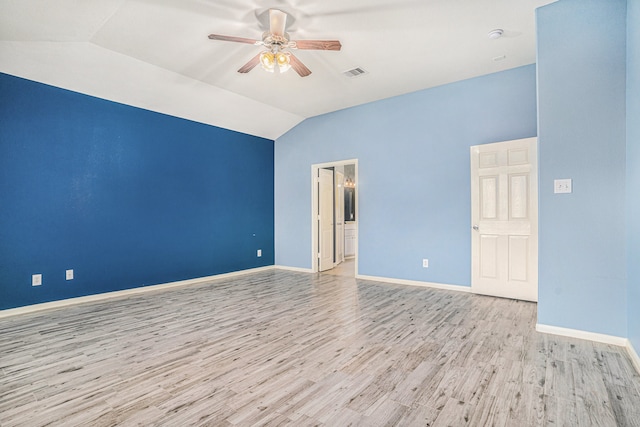 spare room with ceiling fan, lofted ceiling, and light wood-type flooring