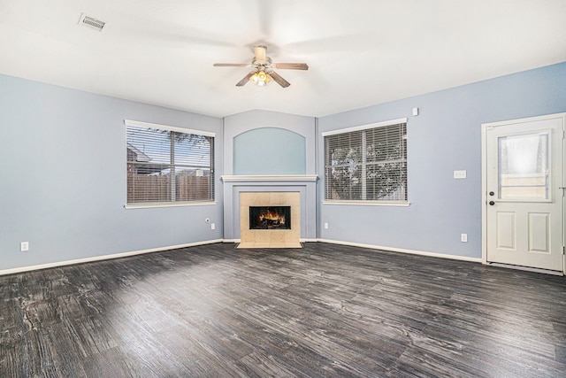 unfurnished living room with ceiling fan, a fireplace, and dark hardwood / wood-style floors