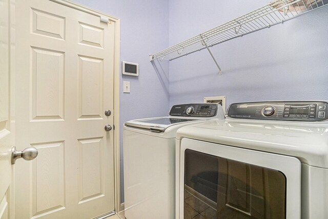 laundry room featuring separate washer and dryer and tile patterned flooring