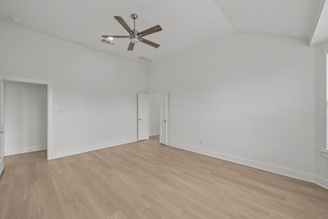 spare room with visible vents, ceiling fan, light wood-style floors, and vaulted ceiling