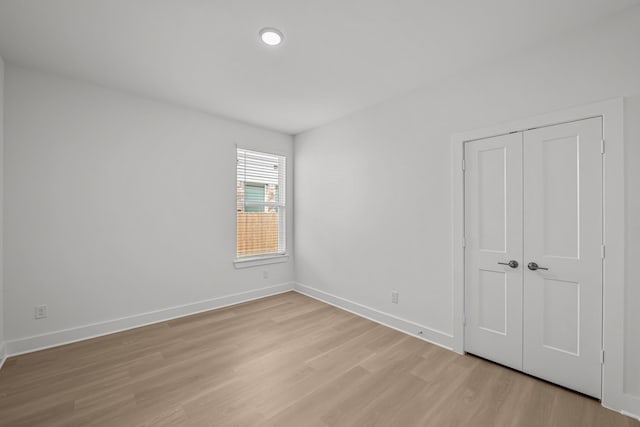 empty room featuring light wood finished floors and baseboards