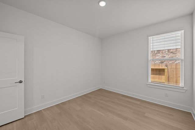 empty room with light wood-style floors and baseboards