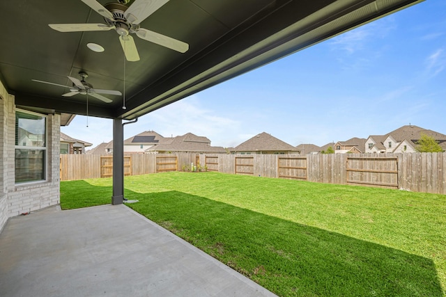 view of yard featuring a patio, ceiling fan, a fenced backyard, and a residential view
