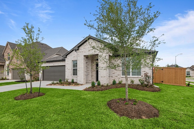french country style house with a garage, brick siding, a front yard, and concrete driveway
