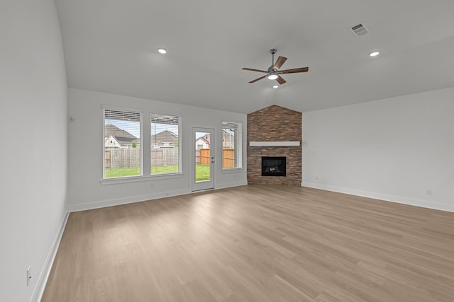 unfurnished living room with ceiling fan, visible vents, vaulted ceiling, and baseboards