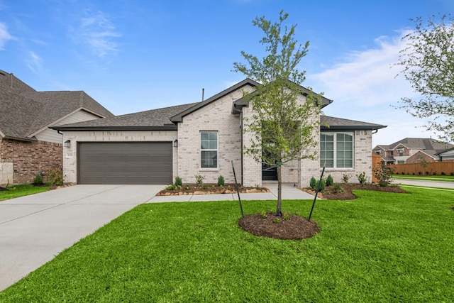 view of front facade with concrete driveway, a front yard, an attached garage, and brick siding