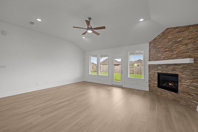 unfurnished living room featuring light wood finished floors, a fireplace, a ceiling fan, visible vents, and vaulted ceiling